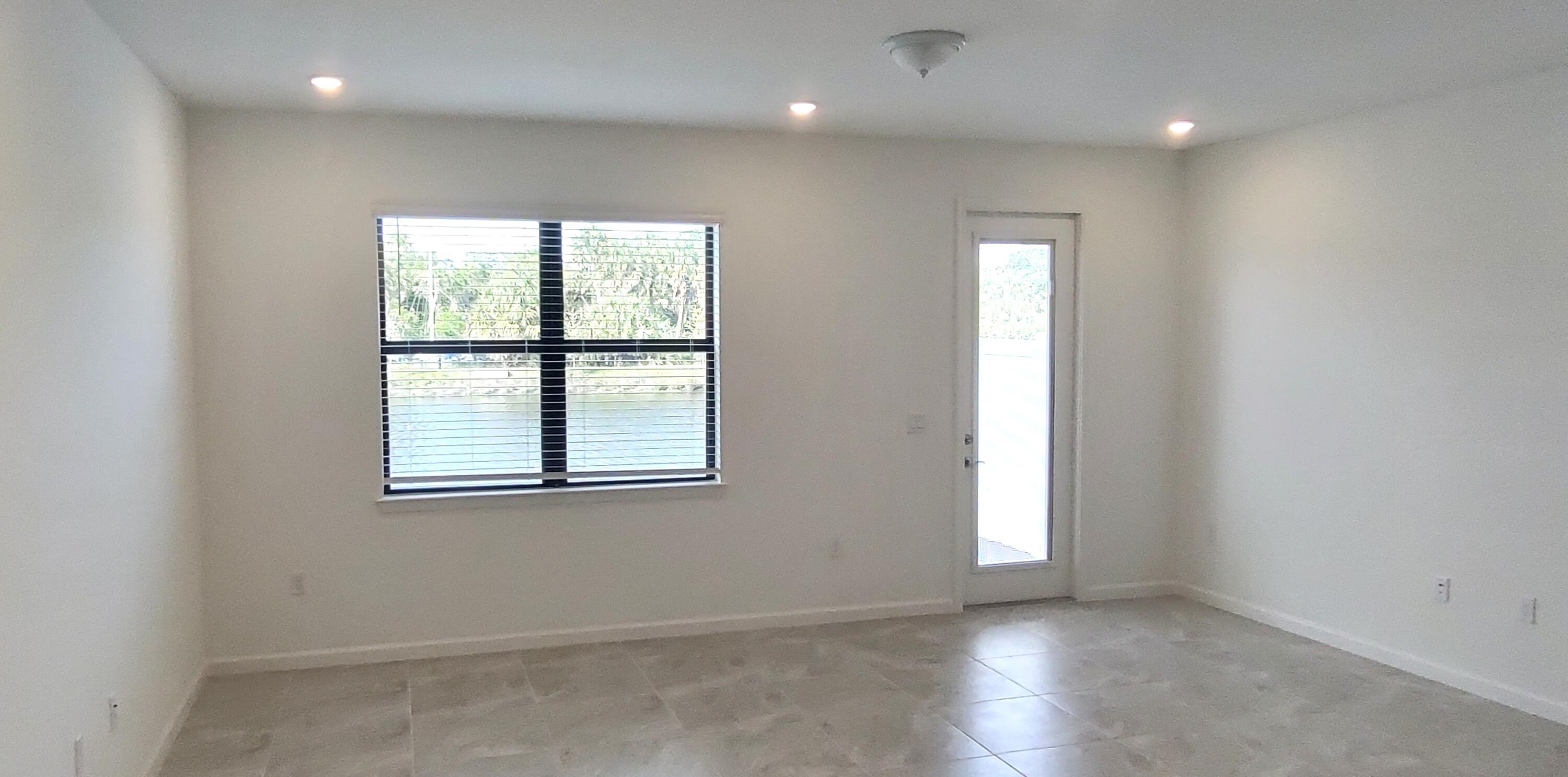 7783 Southwest Bentley Lane Stuart, FL 34997 - Photo 4 of 34 an empty room with wooden floor and windows