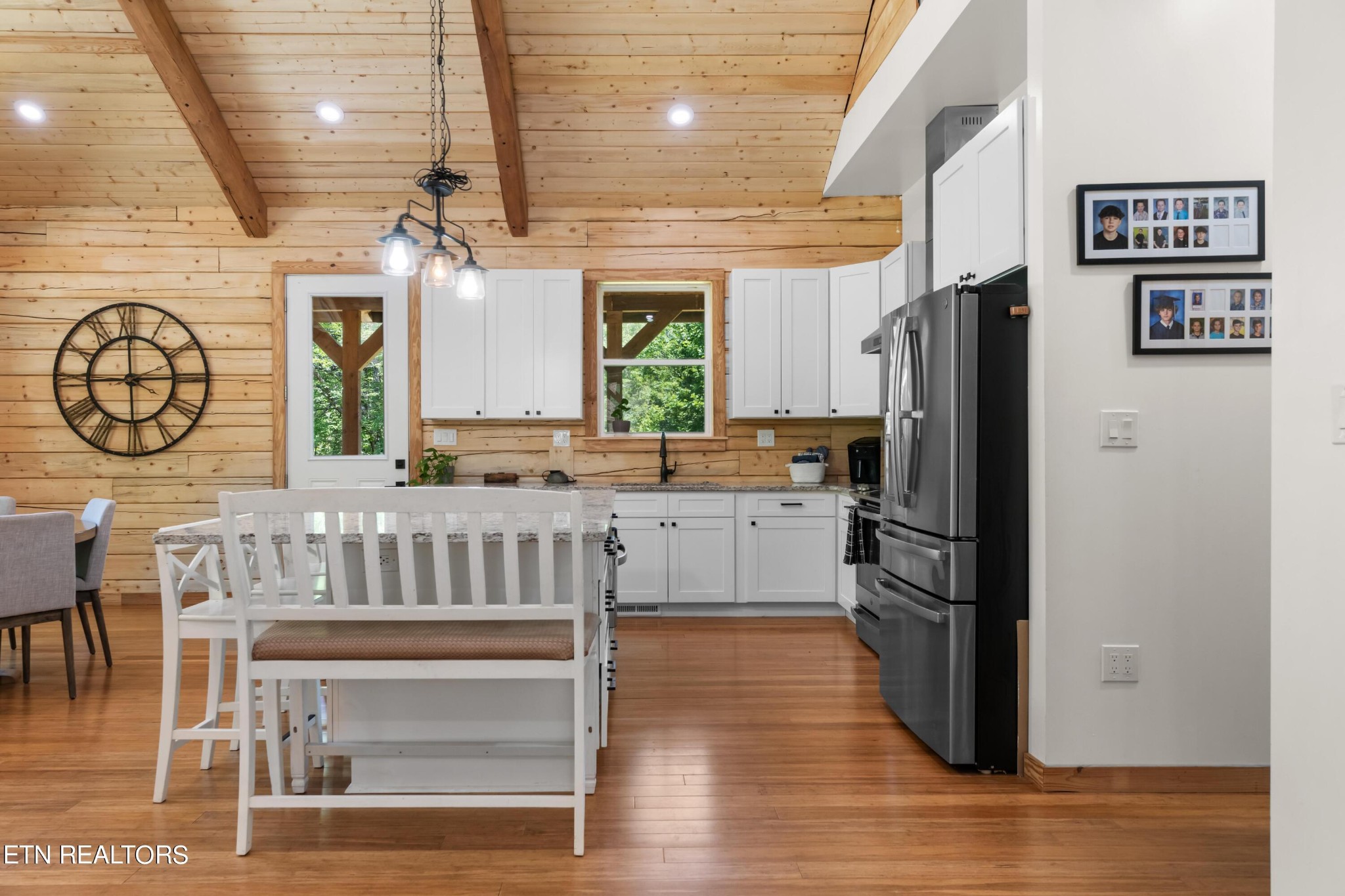 157 Foust Hollow Road Heiskell, TN 37754 - Photo 10 of 34 a kitchen with stainless steel appliances granite countertop a refrigerator a stove a microwave oven a dining table and chairs with wooden floor