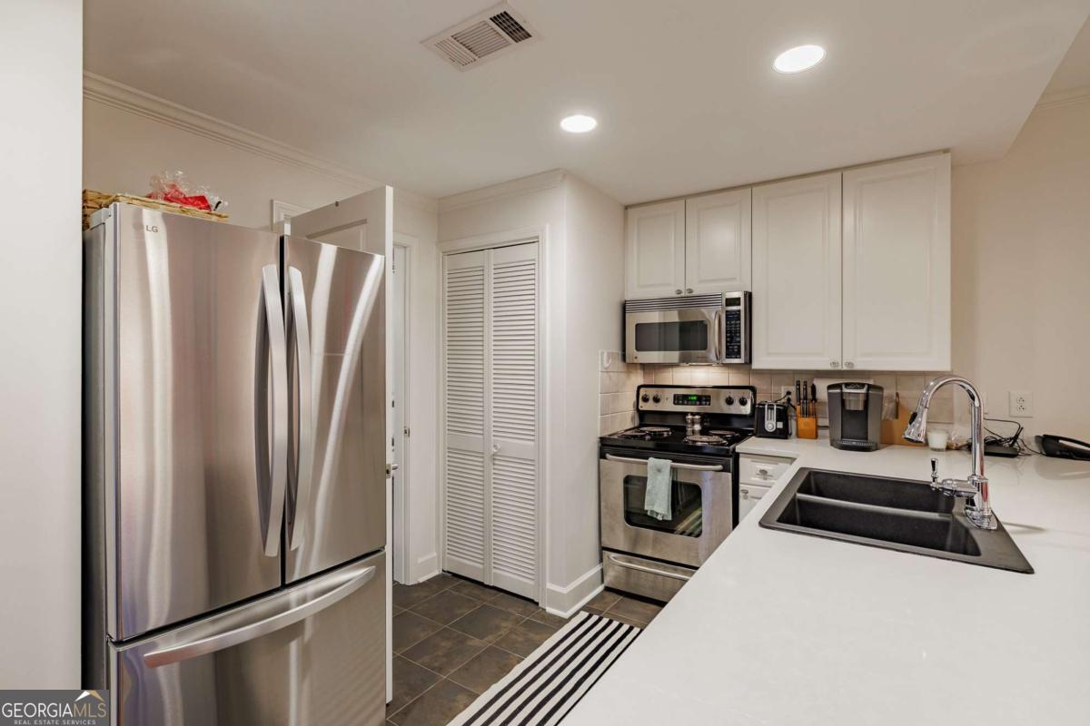 250 West Broad Street, Unit 714 Athens, GA 30601 - Photo 8 of 21 a kitchen with stainless steel appliances granite countertop a refrigerator a stove and a sink
