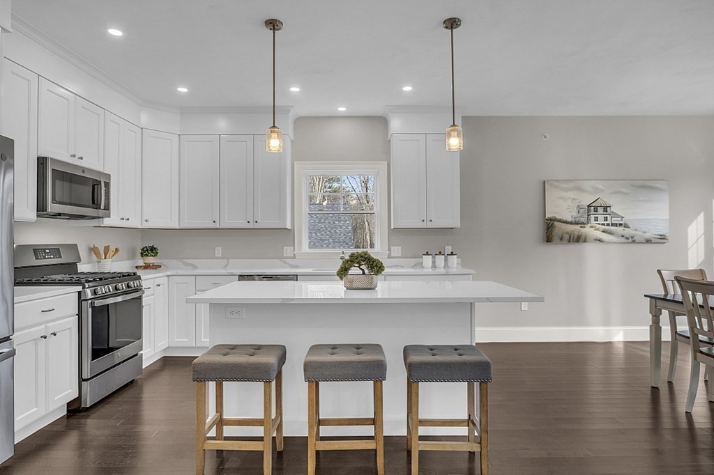 6 Shoemaker Lane, Unit 19 Upton, MA 01568 - Photo 9 of 30 a kitchen with a dining table chairs sink and cabinets