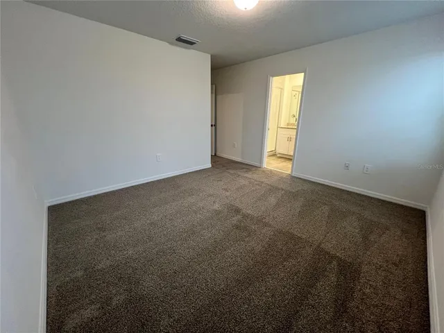 a spacious bathroom with a granite countertop sink and a mirror