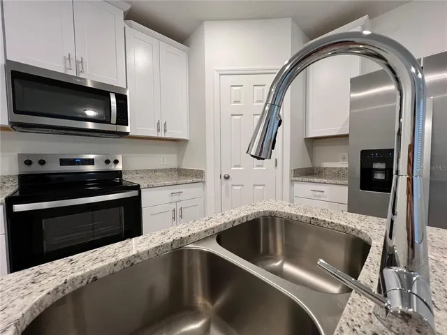 a kitchen with a sink cabinets and stainless steel appliances