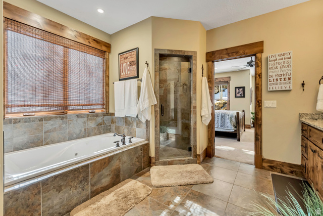 9049 Timphaven Road Sundance, UT 84604 - Photo 20 of 63 Ensuite bathroom with vanity, a stall shower, a jetted tub, light tile patterned floors, and ceiling fan