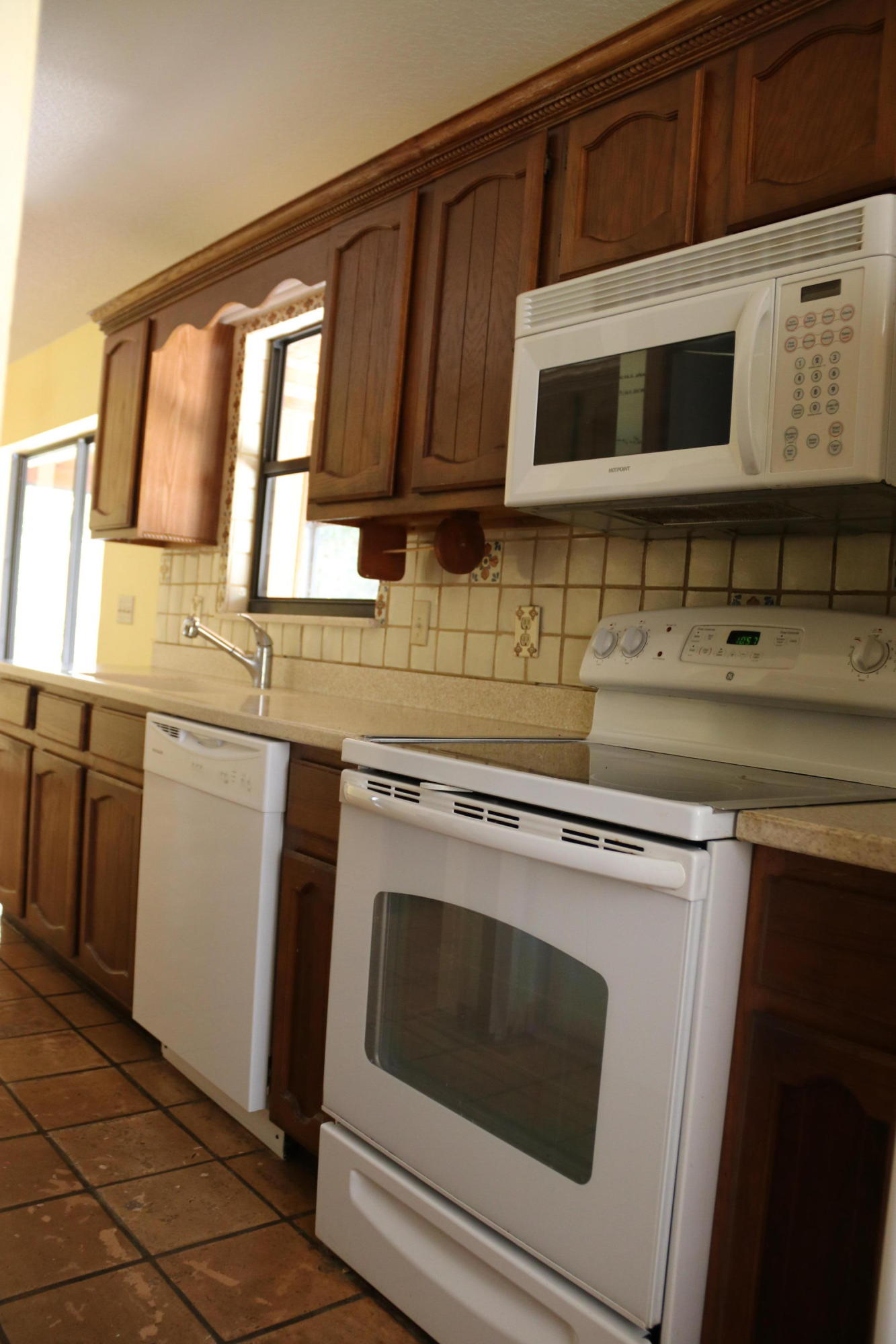 6098 Kendrick Street Jupiter, FL 33458 - Photo 14 of 15 a kitchen with stainless steel appliances granite countertop a stove microwave and cabinets