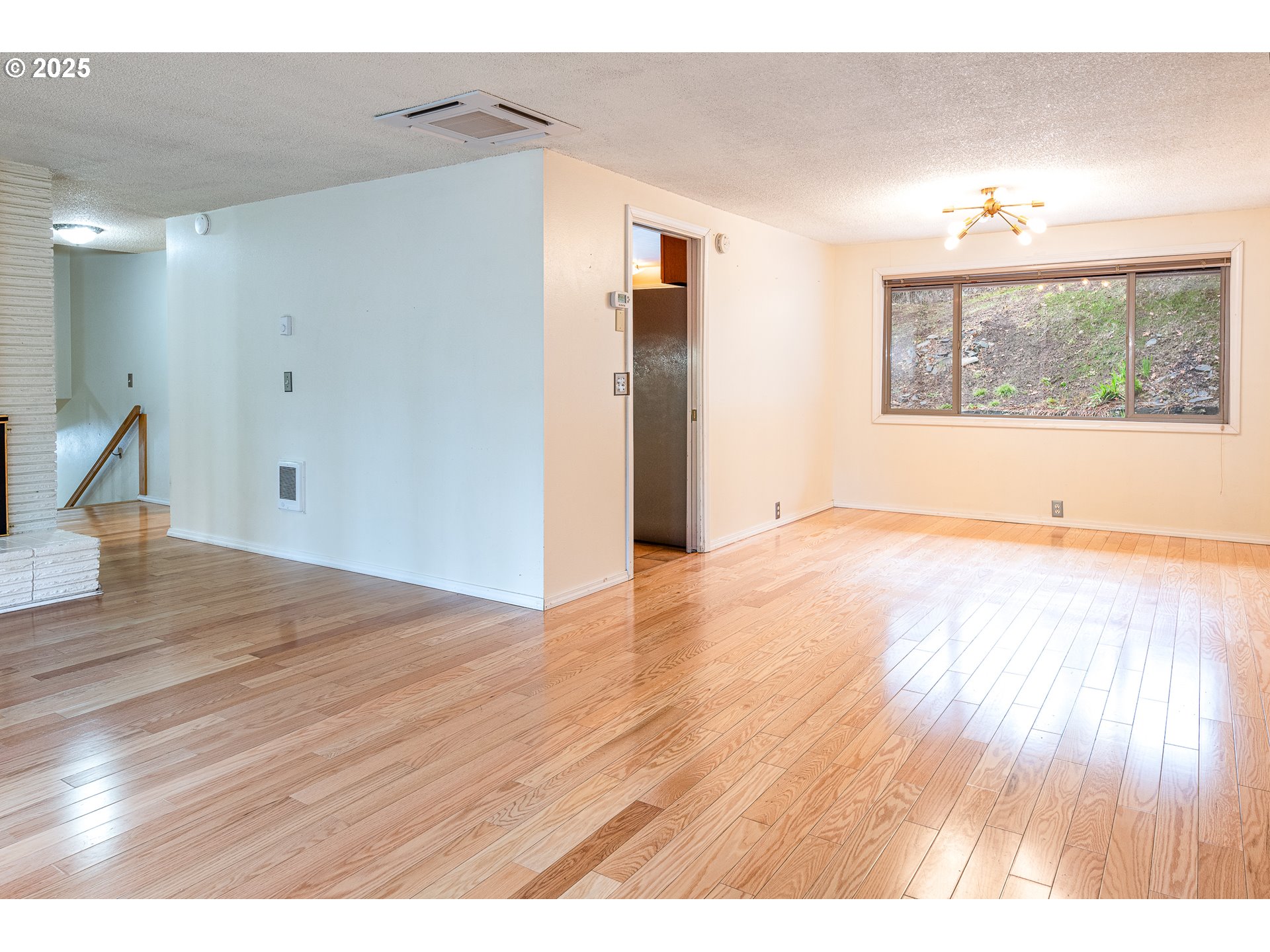 293 Brae Burn Drive Eugene, OR 97405 - Photo 6 of 35 a view of an empty room with wooden floor and a window