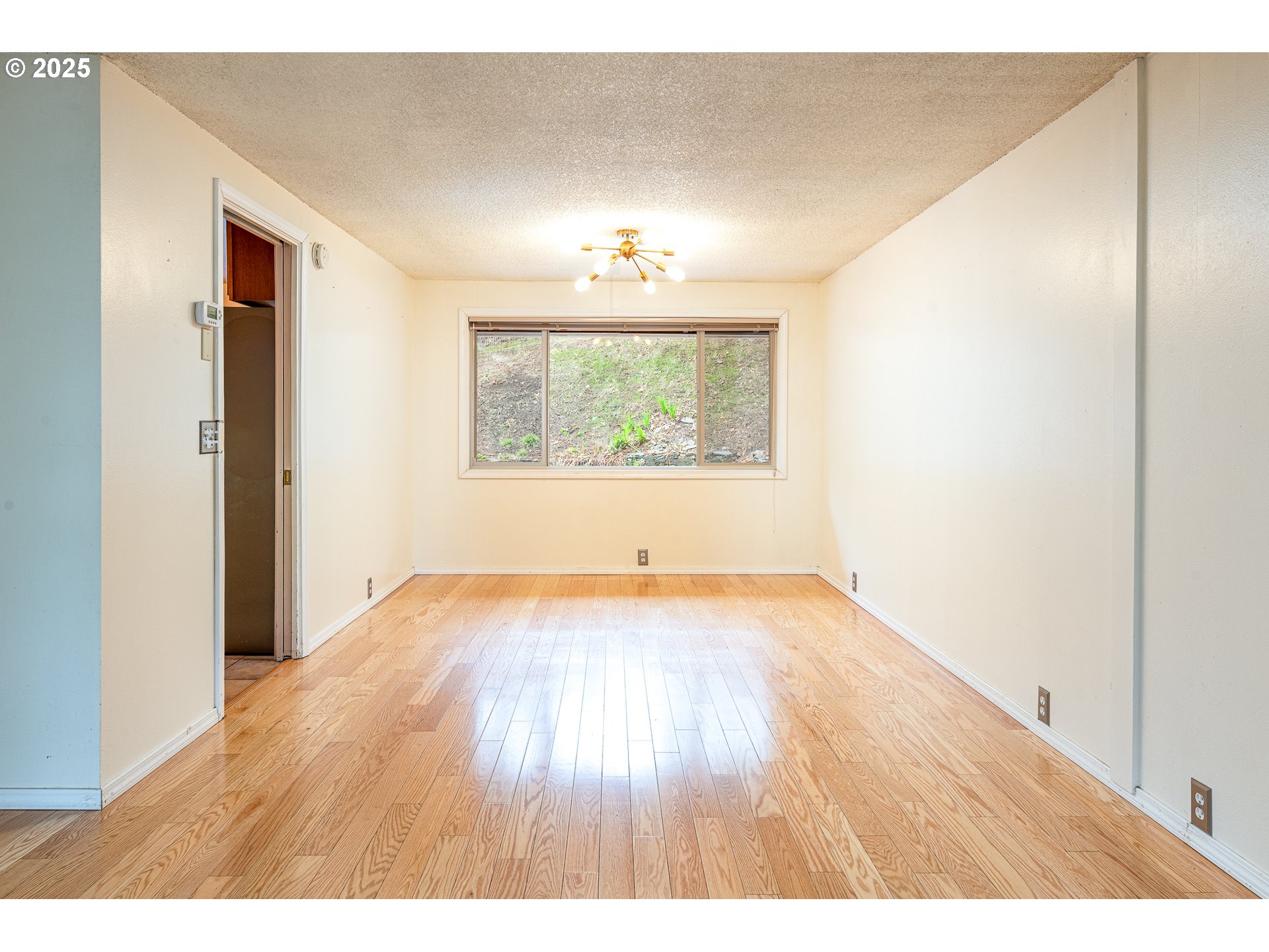 293 Brae Burn Drive Eugene, OR 97405 - Photo 7 of 35 a view of an empty room with wooden floor and a window