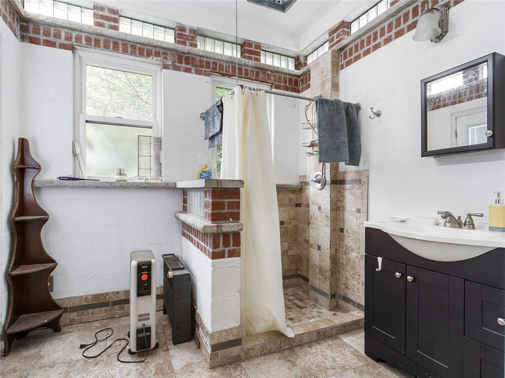 446 76th Street Brooklyn, NY 11209 - Photo 13 of 35 a bathroom with a double vanity sink a mirror and a shower