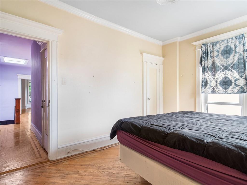 446 76th Street Brooklyn, NY 11209 - Photo 17 of 35 a bedroom with a bed and wooden floor