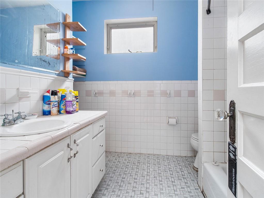 446 76th Street Brooklyn, NY 11209 - Photo 20 of 35 a bathroom with a sink a toilet and shower
