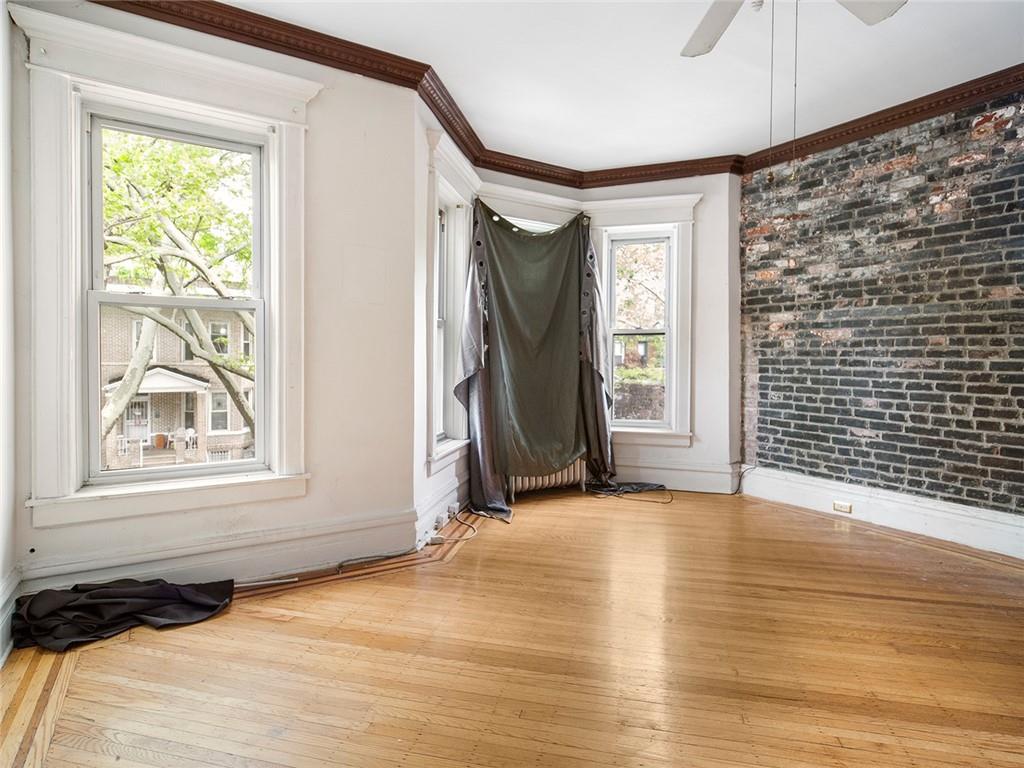 446 76th Street Brooklyn, NY 11209 - Photo 23 of 35 a view of an empty room with a window and wooden floor