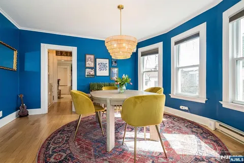 a hallway with white cabinets and chandelier