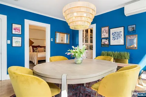 a kitchen with a sink dishwasher a dining table and chairs with wooden floor