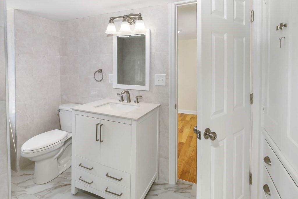 266 Webster Street Worcester, MA 01603 - Photo 35 of 42 a bathroom with a sink a toilet and shower curtain