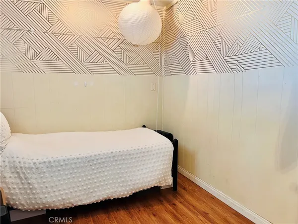 a room with a bed and wooden floor