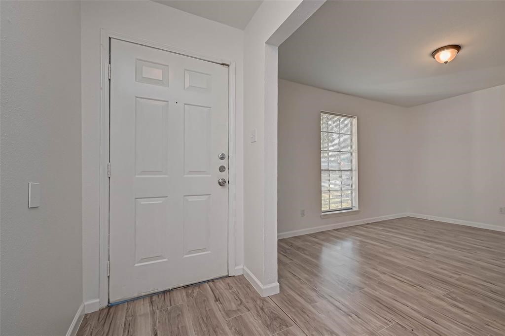 5503 Lynngate Drive Spring, TX 77373 - Photo 3 of 15 a view of an empty room with wooden floor and a window