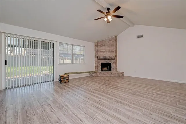 wooden floor in an empty room with a fireplace