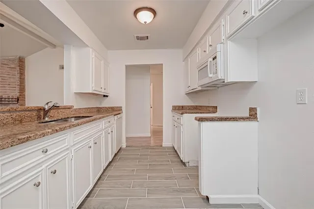 a kitchen with granite countertop a sink and cabinets