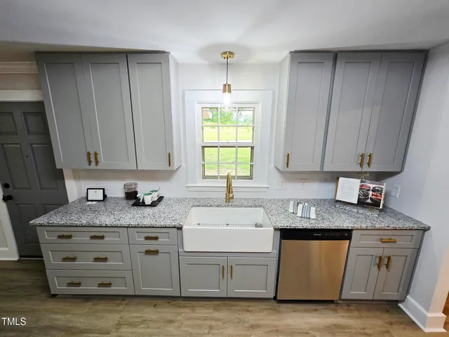 a kitchen with granite countertop a sink cabinets and window