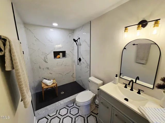 a bathroom with a sink a toilet and a mirror