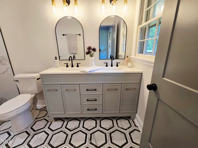 a bathroom with a sink toilet a mirror and shower