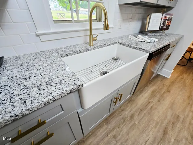 a bathroom with a granite countertop sink and a window