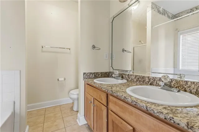 a bathroom with a granite countertop sink a toilet and a mirror