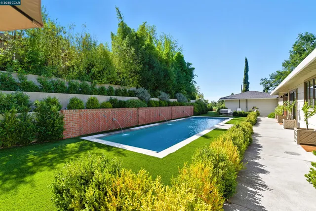 a view of a patio with table and chairs and potted plants with wooden floor and fence