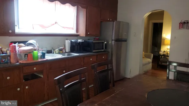 a kitchen with a sink wooden cabinets and a window