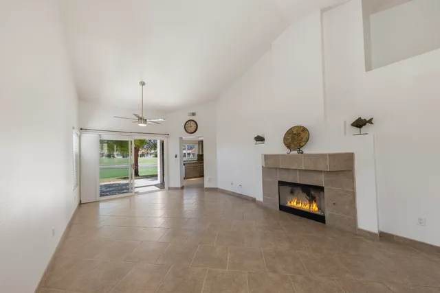 an empty room with windows and fireplace