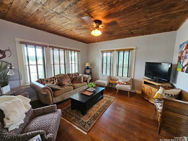 a living room with furniture a flat screen tv and a large window