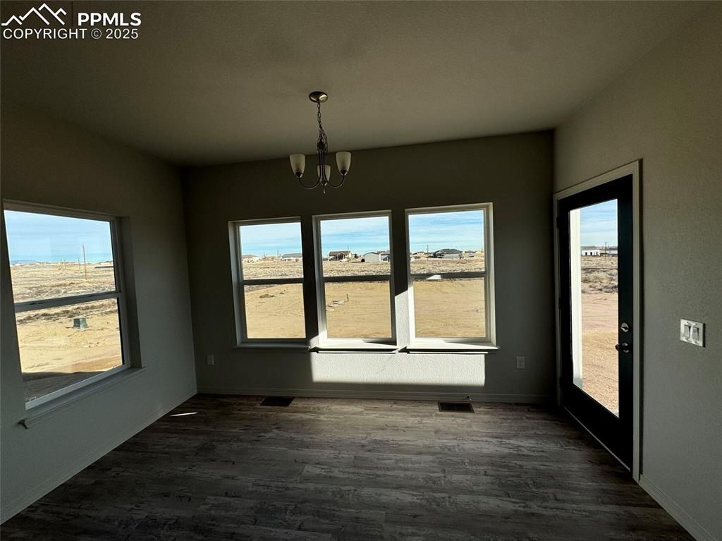 3955 Yoder Road Yoder, CO 80864 - Photo 16 of 27 Unfurnished dining area featuring dark hardwood / wood-style floors and a notable chandelier