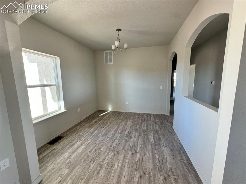 3955 Yoder Road Yoder, CO 80864 - Photo 8 of 27 Unfurnished dining area with a chandelier and hardwood / wood-style flooring