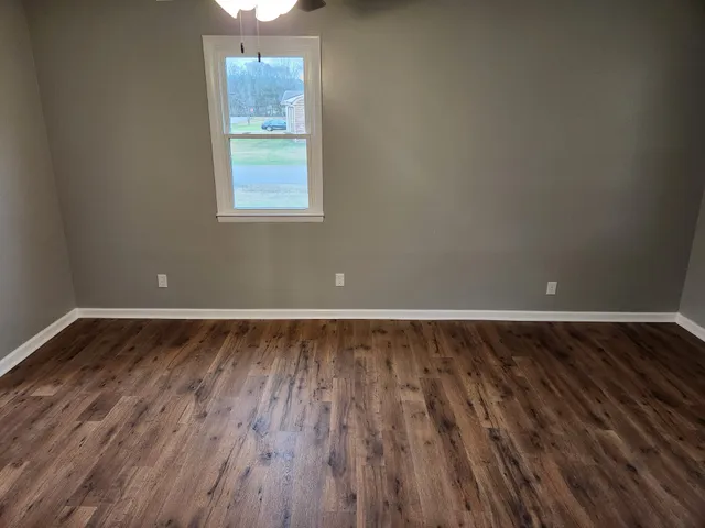 a view of a room with wooden floors and window