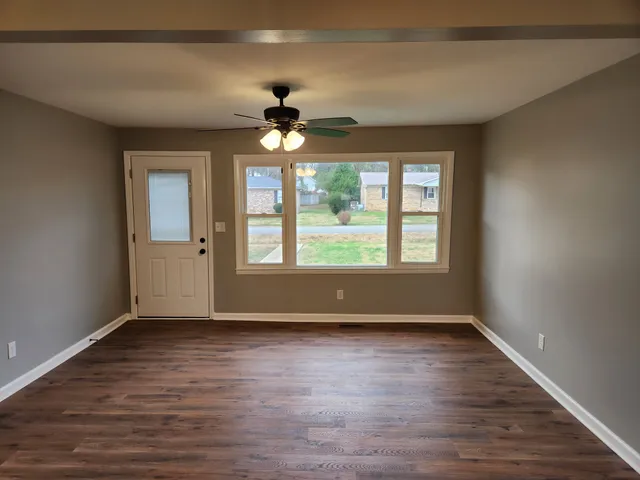 a view of an empty room window and wooden floor