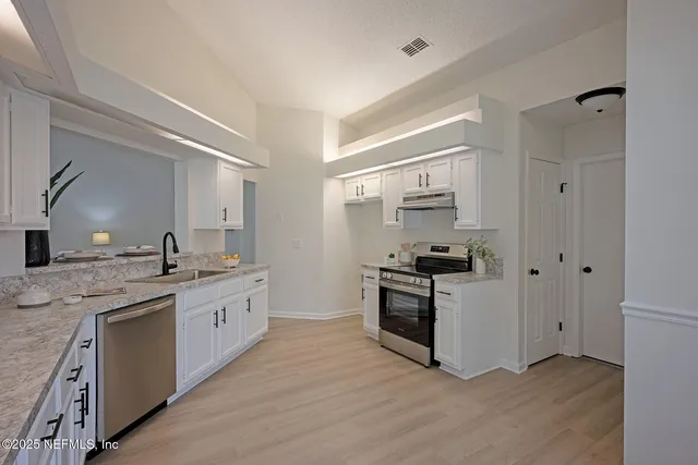 a large kitchen with stainless steel appliances granite countertop a stove and a sink