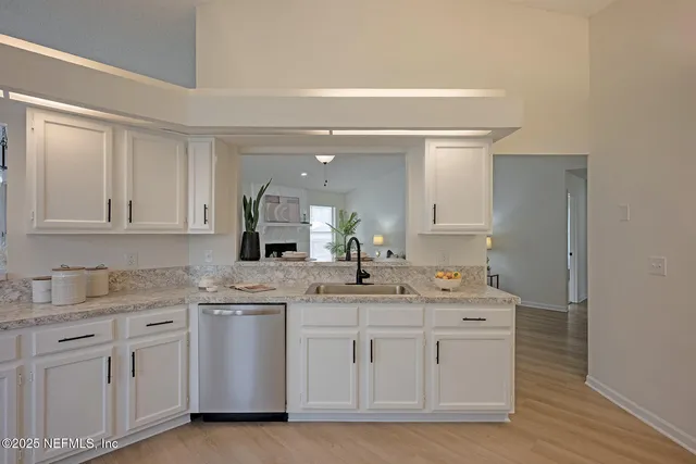 a kitchen with white cabinets sink and stove