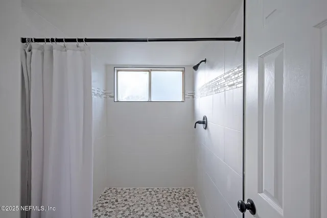 a bathroom with a shower and a window
