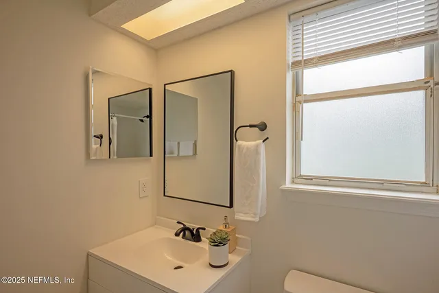 a bathroom with a sink mirror and vanity