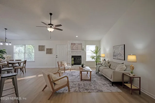 a living room with furniture a fireplace and a chandelier