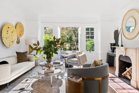 a living room with fireplace furniture and a large window
