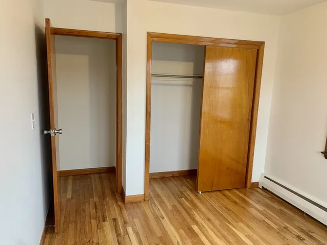 an empty room with wooden floor and closet