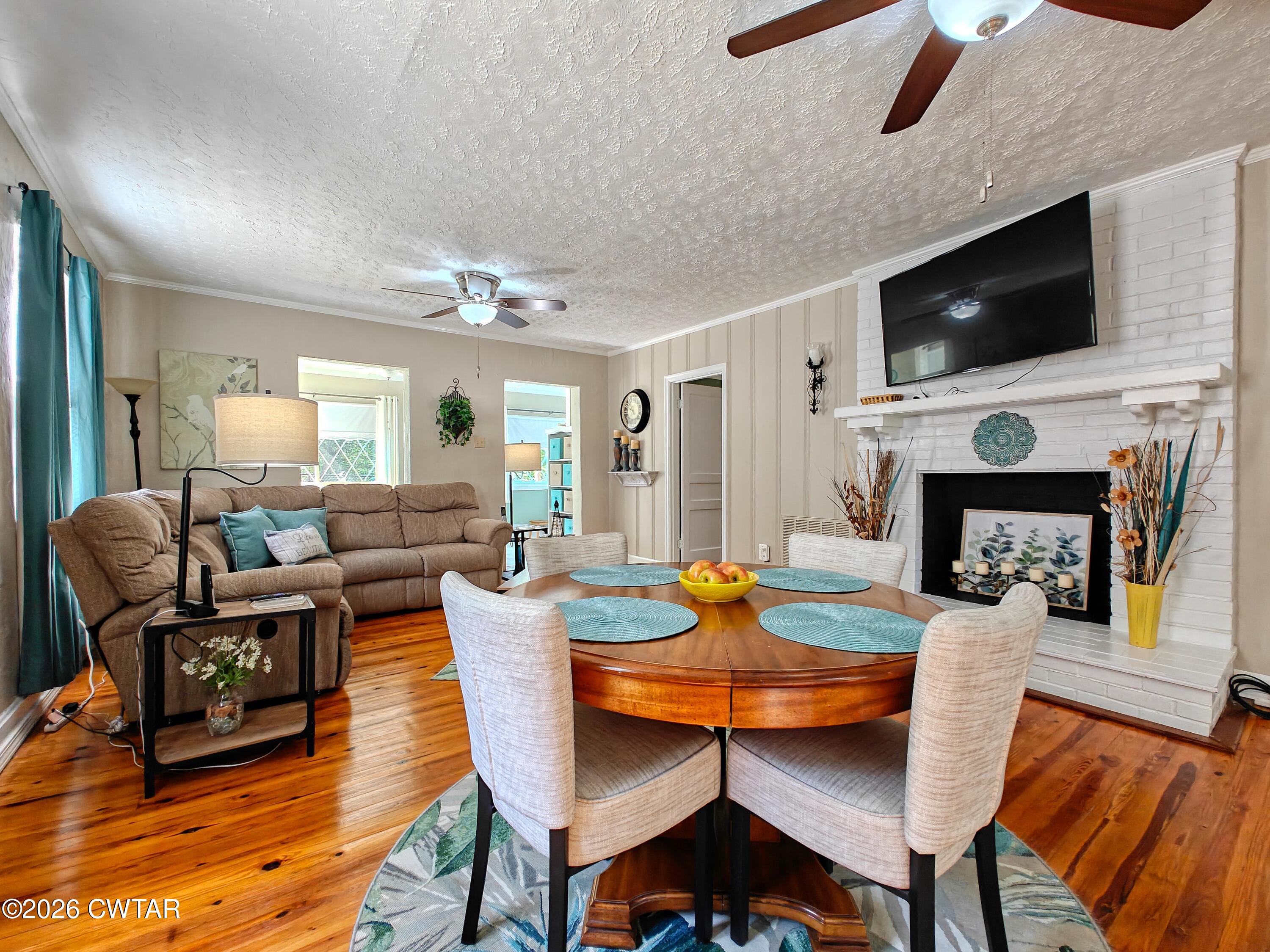 195 Coast Guard Road Buchanan, TN 38222 - Photo 13 of 34 a dining room with furniture a rug a fireplace and a chandelier
