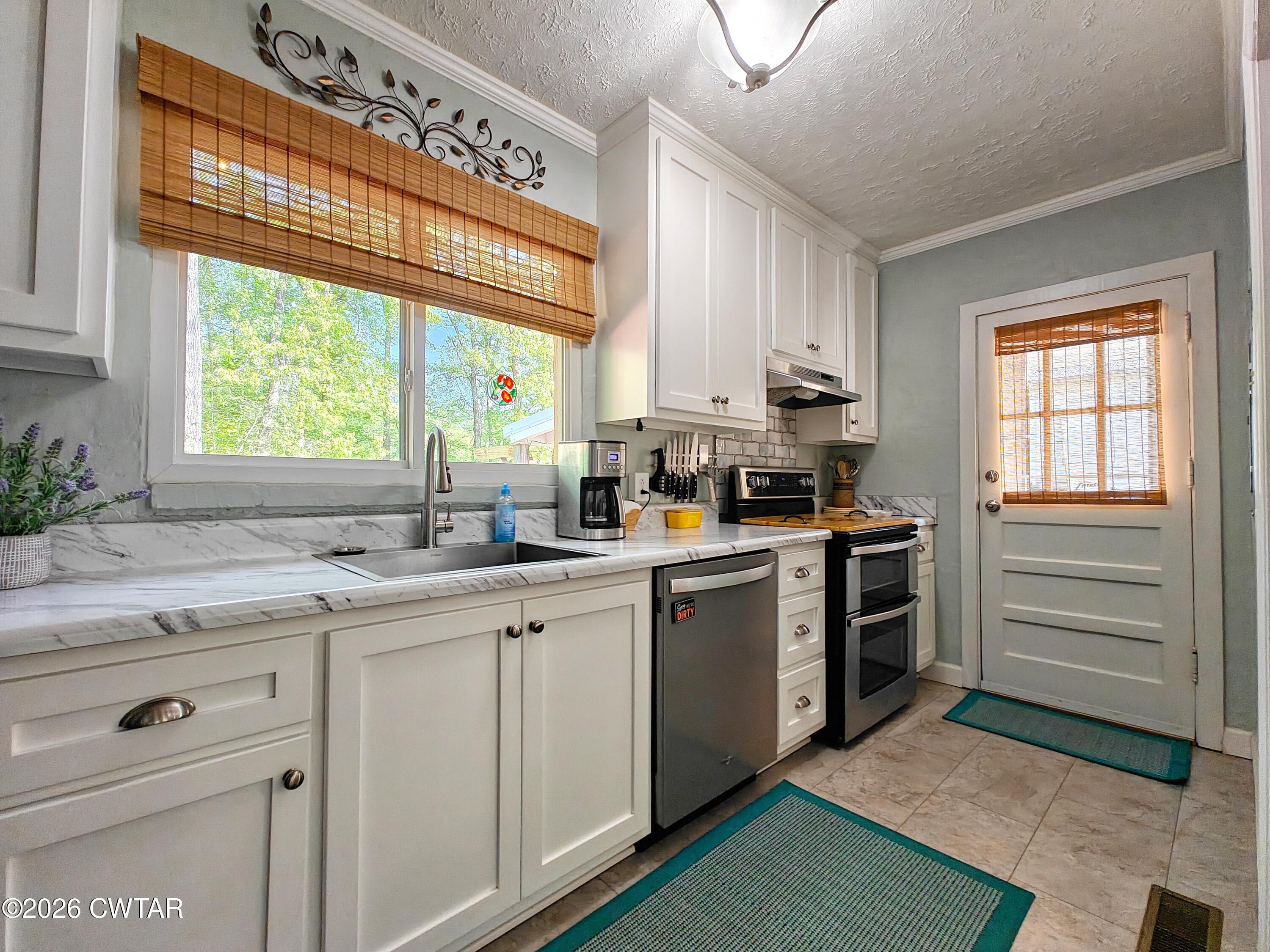 195 Coast Guard Road Buchanan, TN 38222 - Photo 15 of 34 a kitchen with a sink stove and cabinets