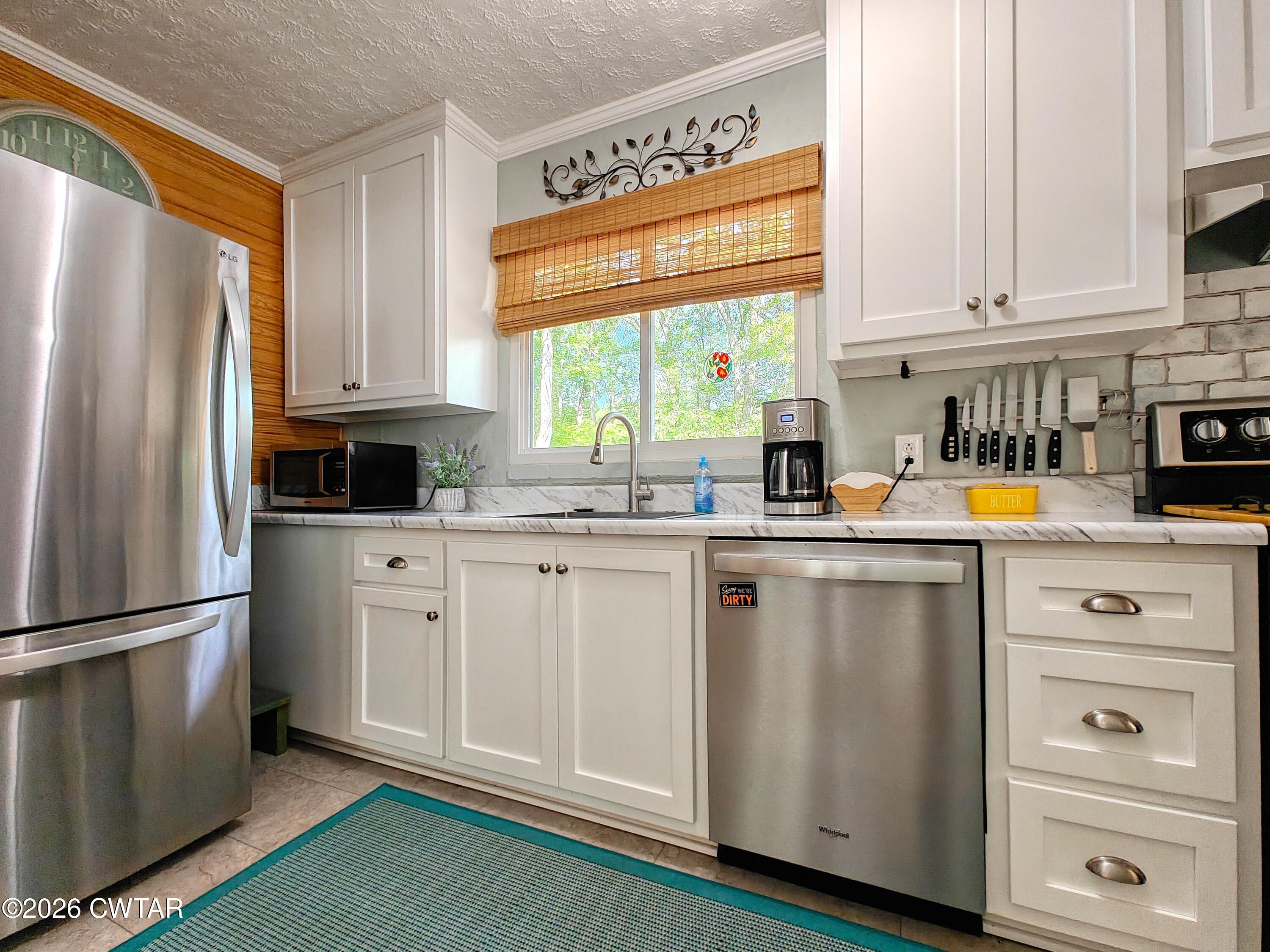 195 Coast Guard Road Buchanan, TN 38222 - Photo 16 of 34 a kitchen with stainless steel appliances a refrigerator sink and cabinets