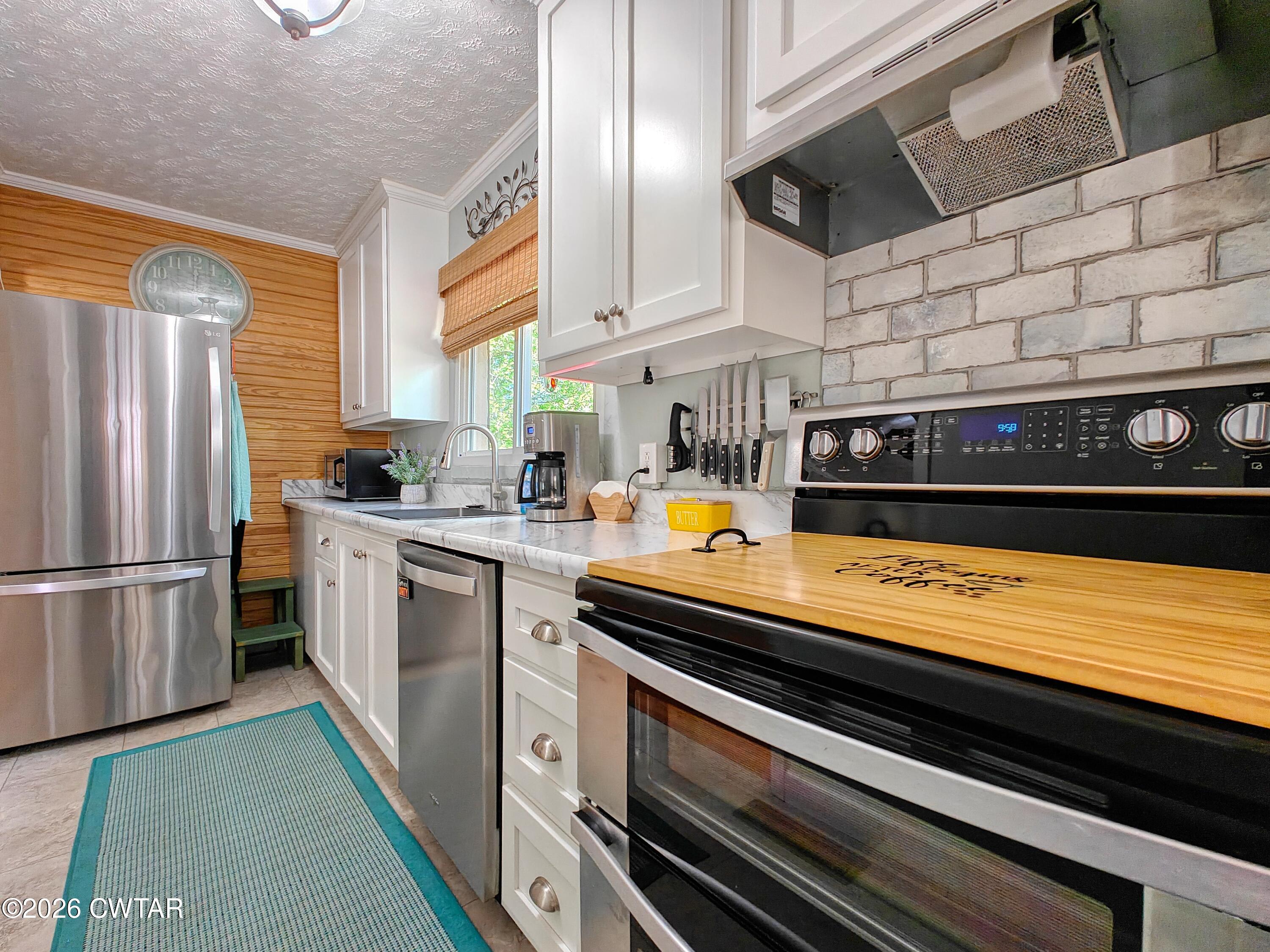 195 Coast Guard Road Buchanan, TN 38222 - Photo 17 of 34 a kitchen with stainless steel appliances a sink and a refrigerator