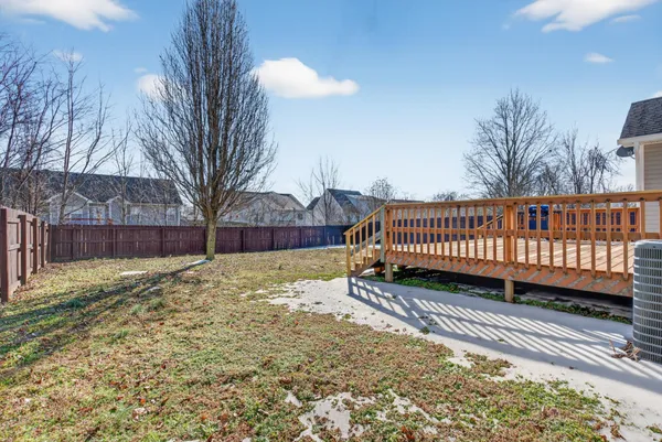 a view of a yard with wooden fence