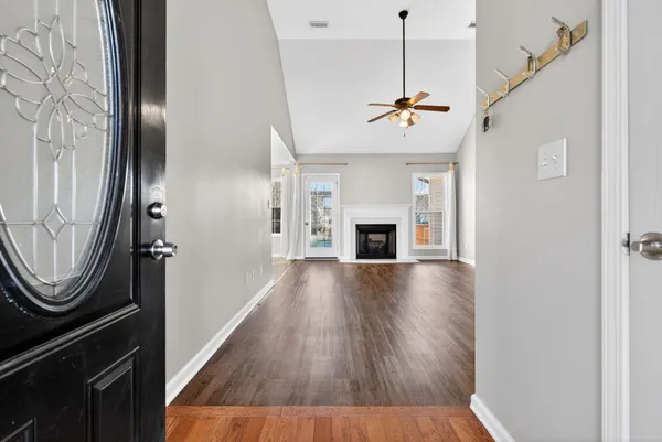 a view of a livingroom with wooden floor and a ceiling fan