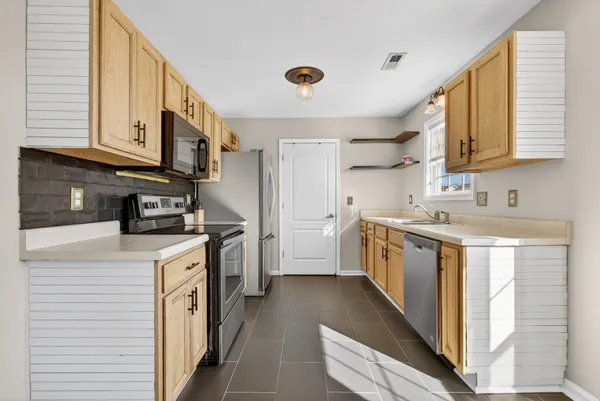 a kitchen with a sink a stove and cabinets