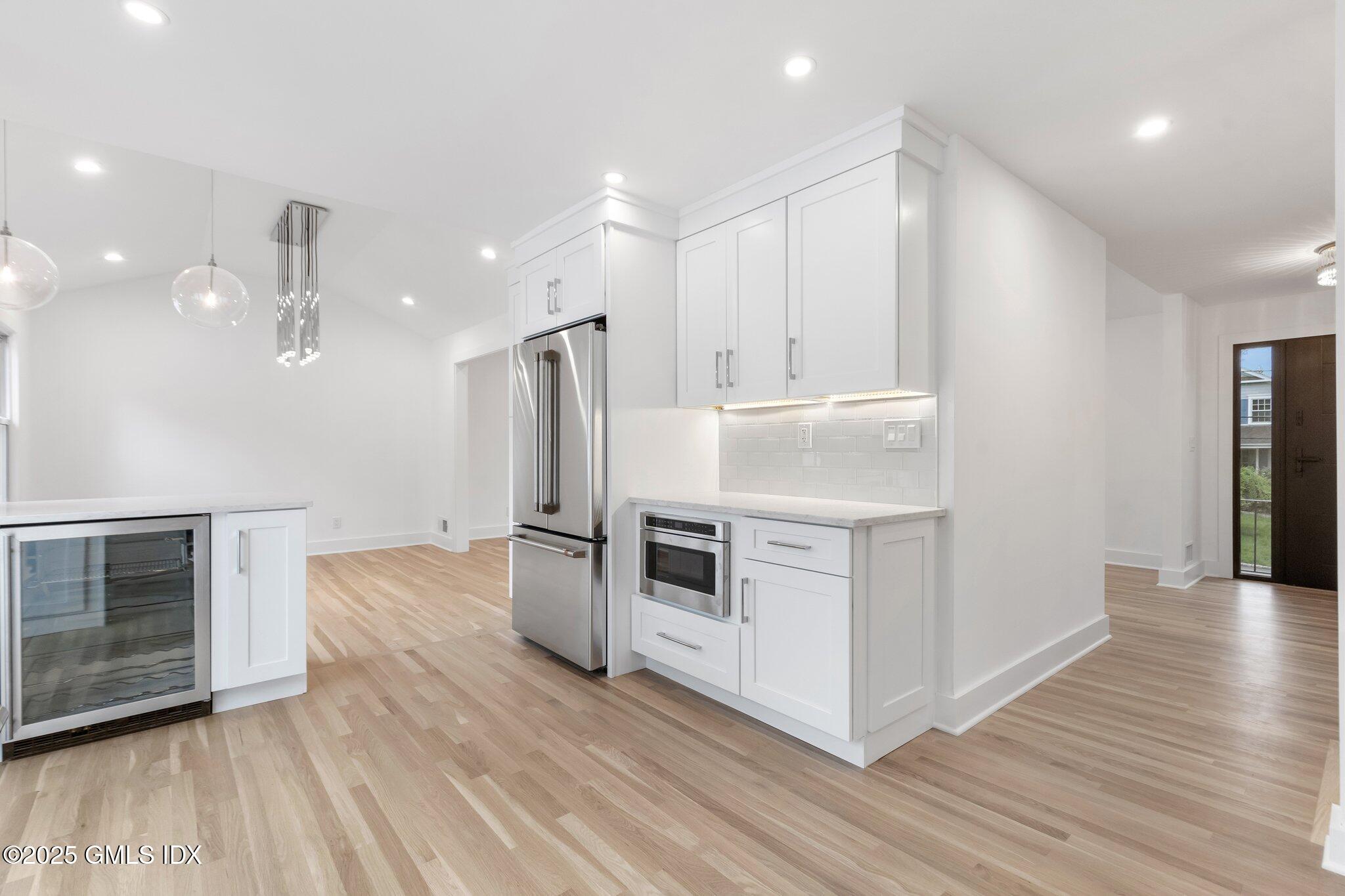 8 Pintail Lane Greenwich, CT 06830 - Photo 12 of 37 a kitchen with stainless steel appliances kitchen island granite countertop a stove a refrigerator and a microwave with wooden floors