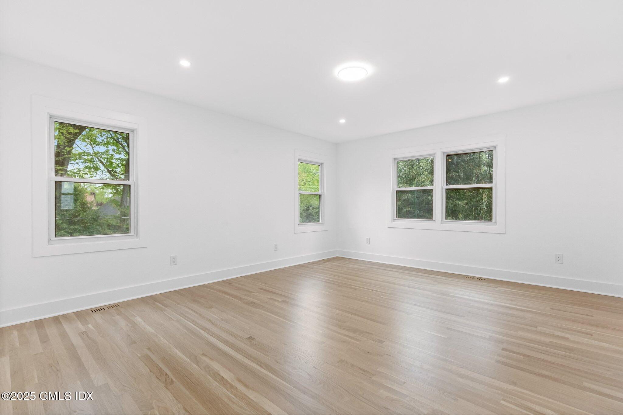 8 Pintail Lane Greenwich, CT 06830 - Photo 15 of 37 an empty room with wooden floor and windows